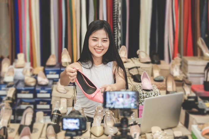 Woman Holding Pink Shoe in Front on Camera for Online Livestream Channel