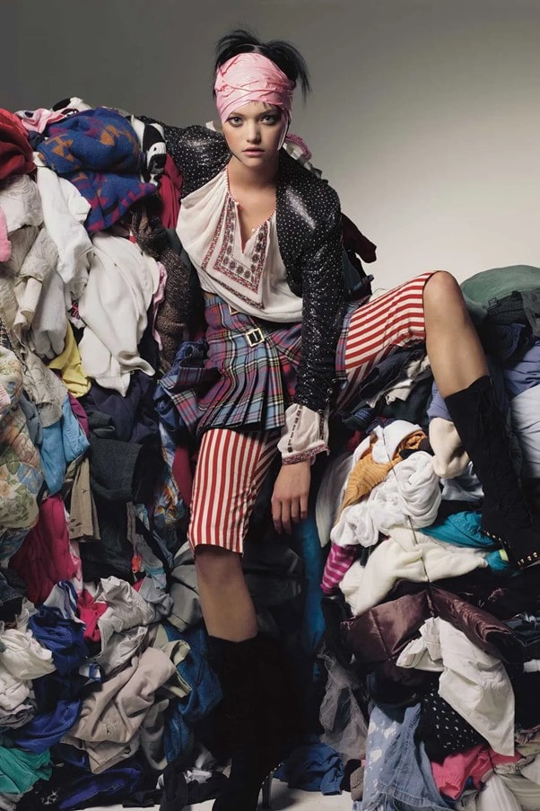 Vogue Model Posing Sitting on Pile of Clothing